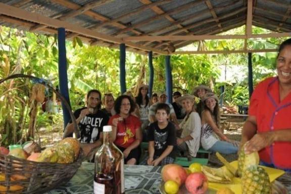 a group of people sitting at a fruit stand